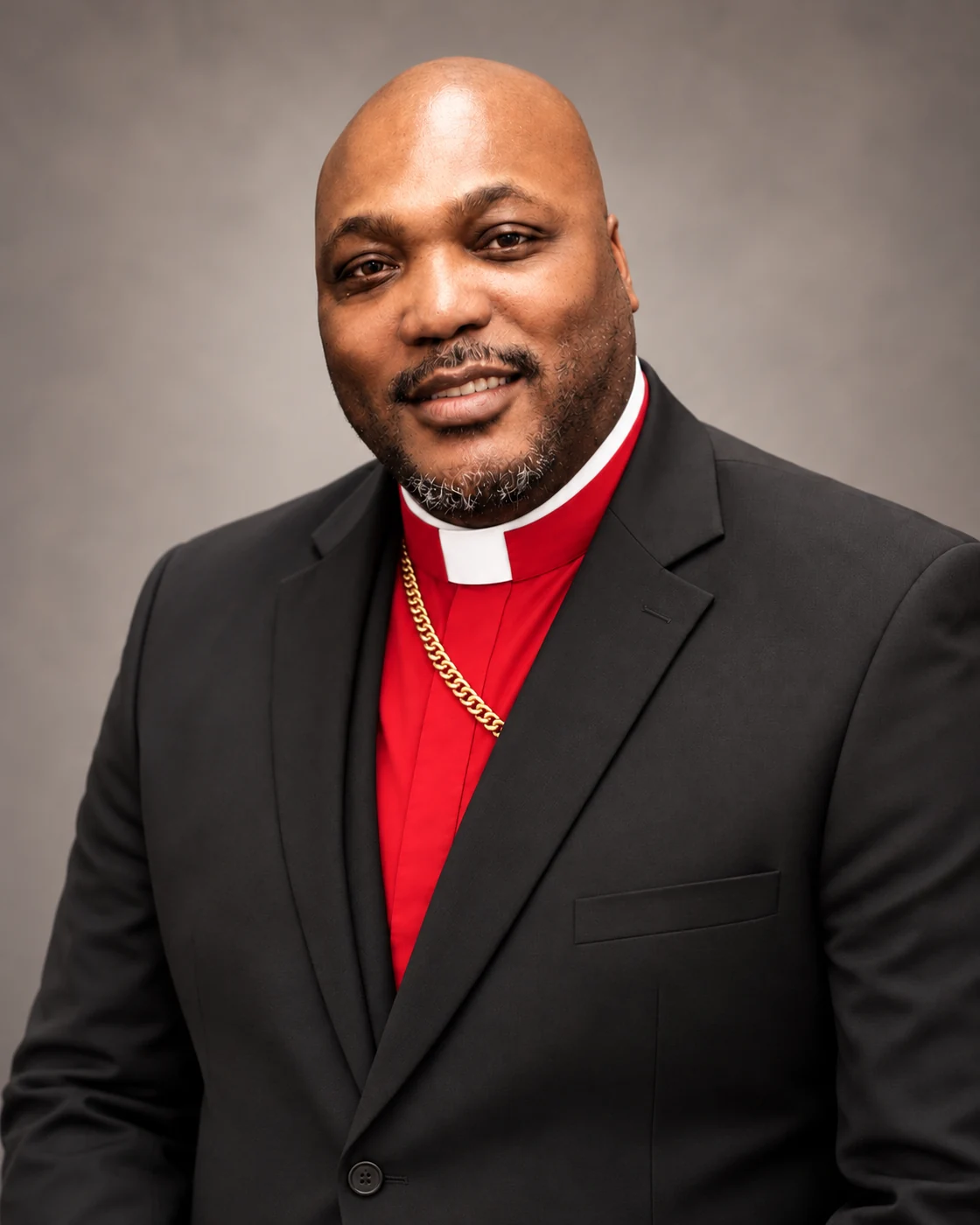 Chief Apostle Dr. Ruben L. Broadnax Jr. in black jacket and red clerical shirt